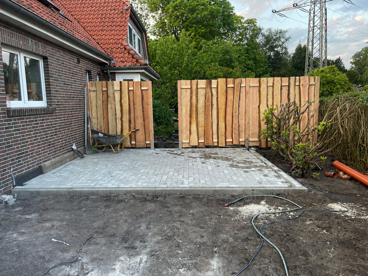 Fertig gepflasterte Terrasse mit Randeinfassung und neuem Sichtschutz